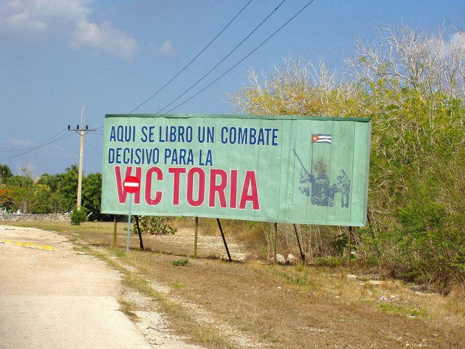 Foto: Propagandaschild mit der Aufschrift "aqui se libro un combate decisivo para la victoria" (dt.: Hier entschied sich eine entscheidende Schlacht um den Sieg), Schweinebucht, Kuba. / Steph32 / CC BY-SA 3.0